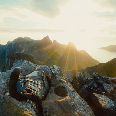 Person på toppen av fjell i solnedgang