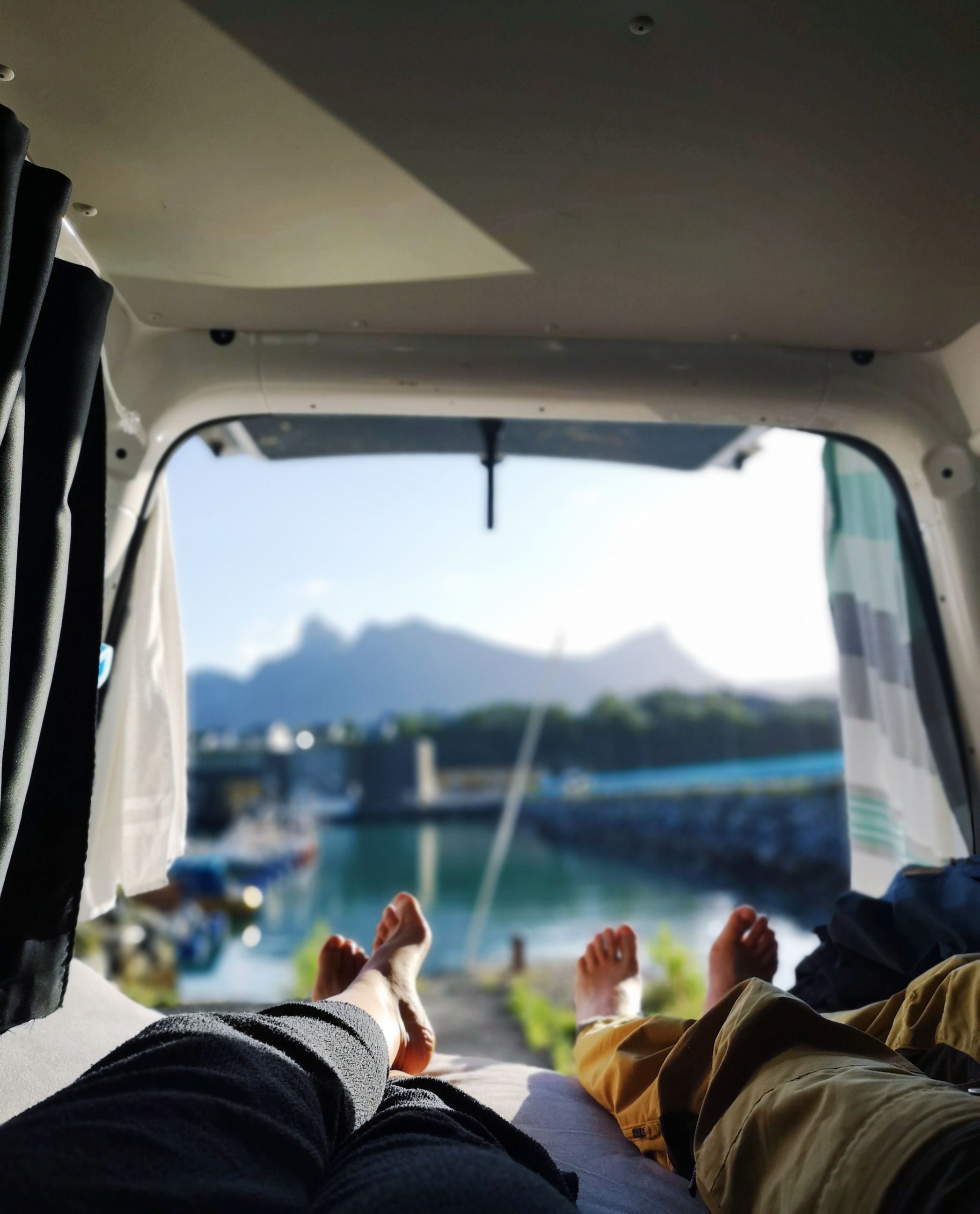 Kvinne og mann ligger barfot i bil og ser på utsikt
